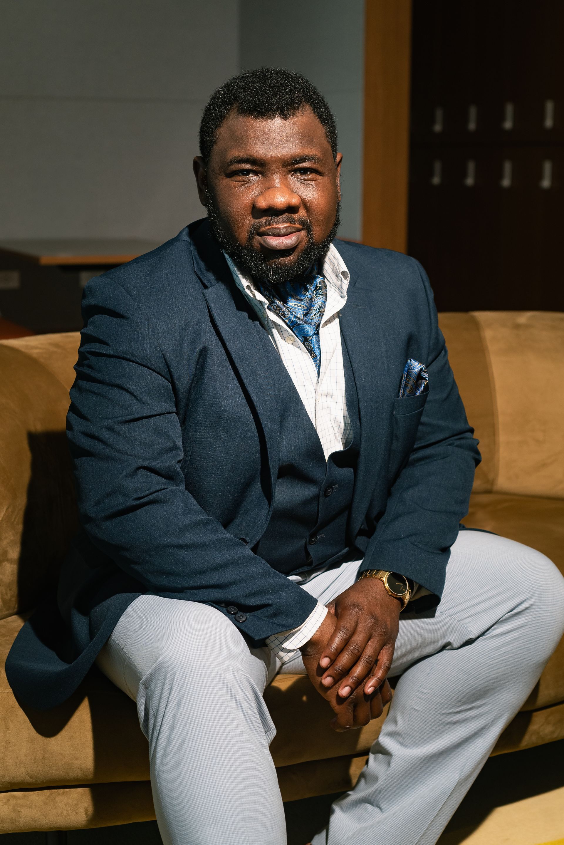 Portrait of Dr.  Omotola Ajibade seated on a couch