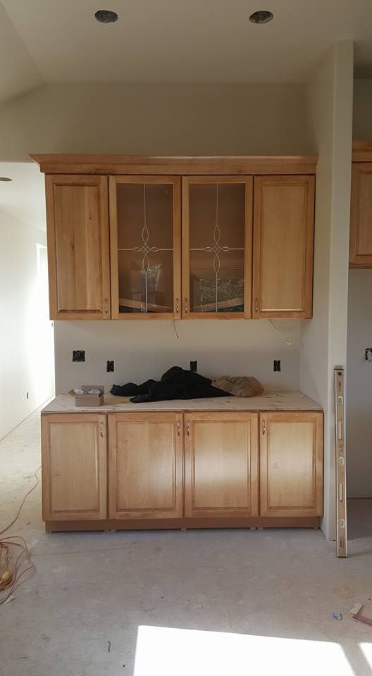 A kitchen with wooden cabinets and glass doors is being remodeled.