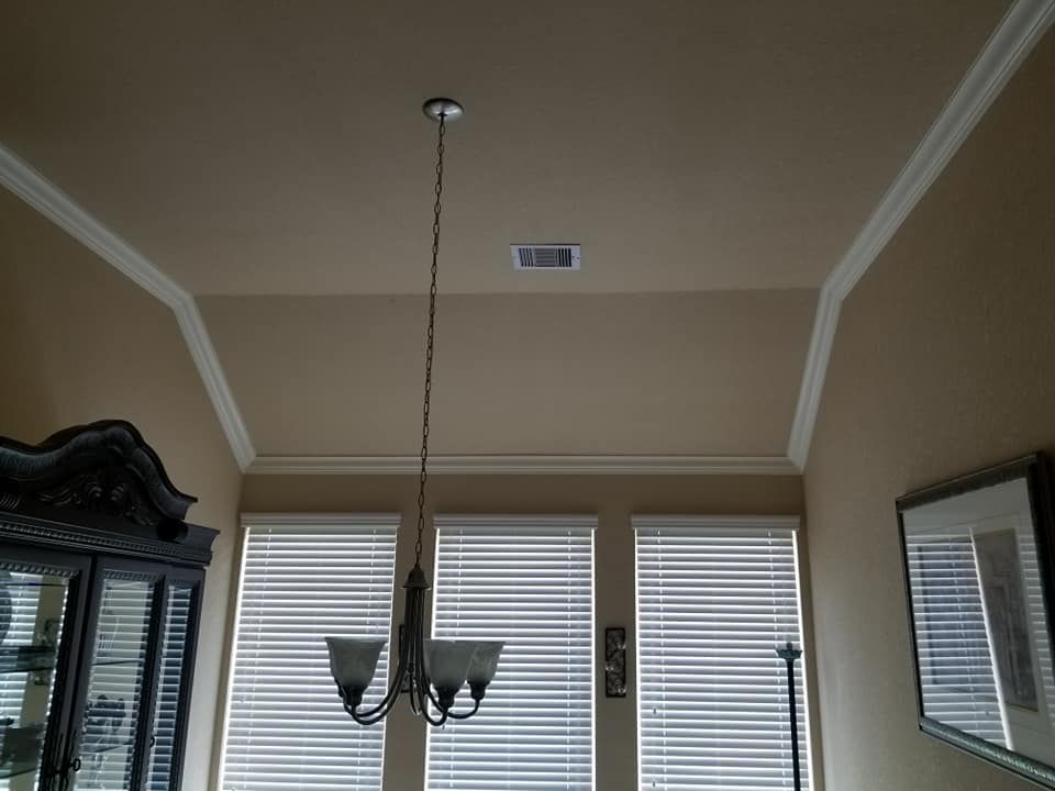 A dining room with a chandelier hanging from the ceiling.