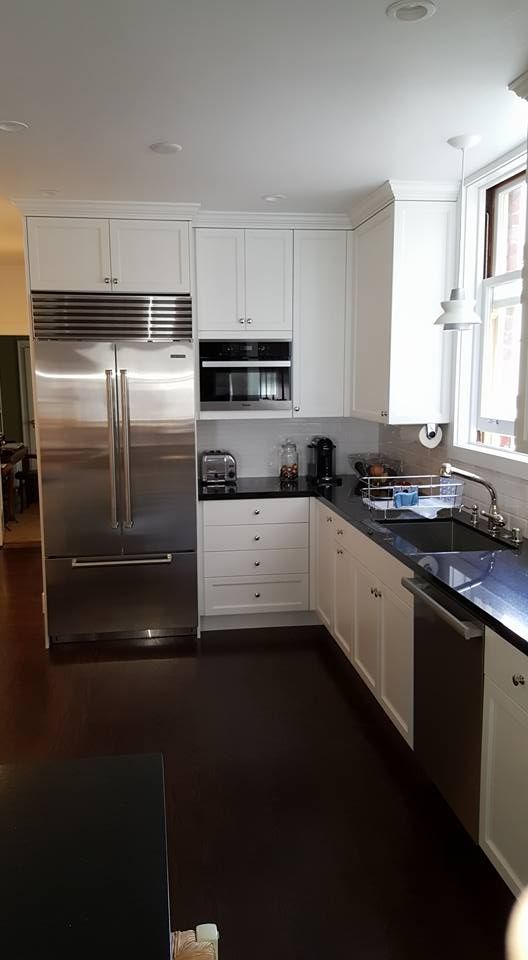 A kitchen with stainless steel appliances and white cabinets.