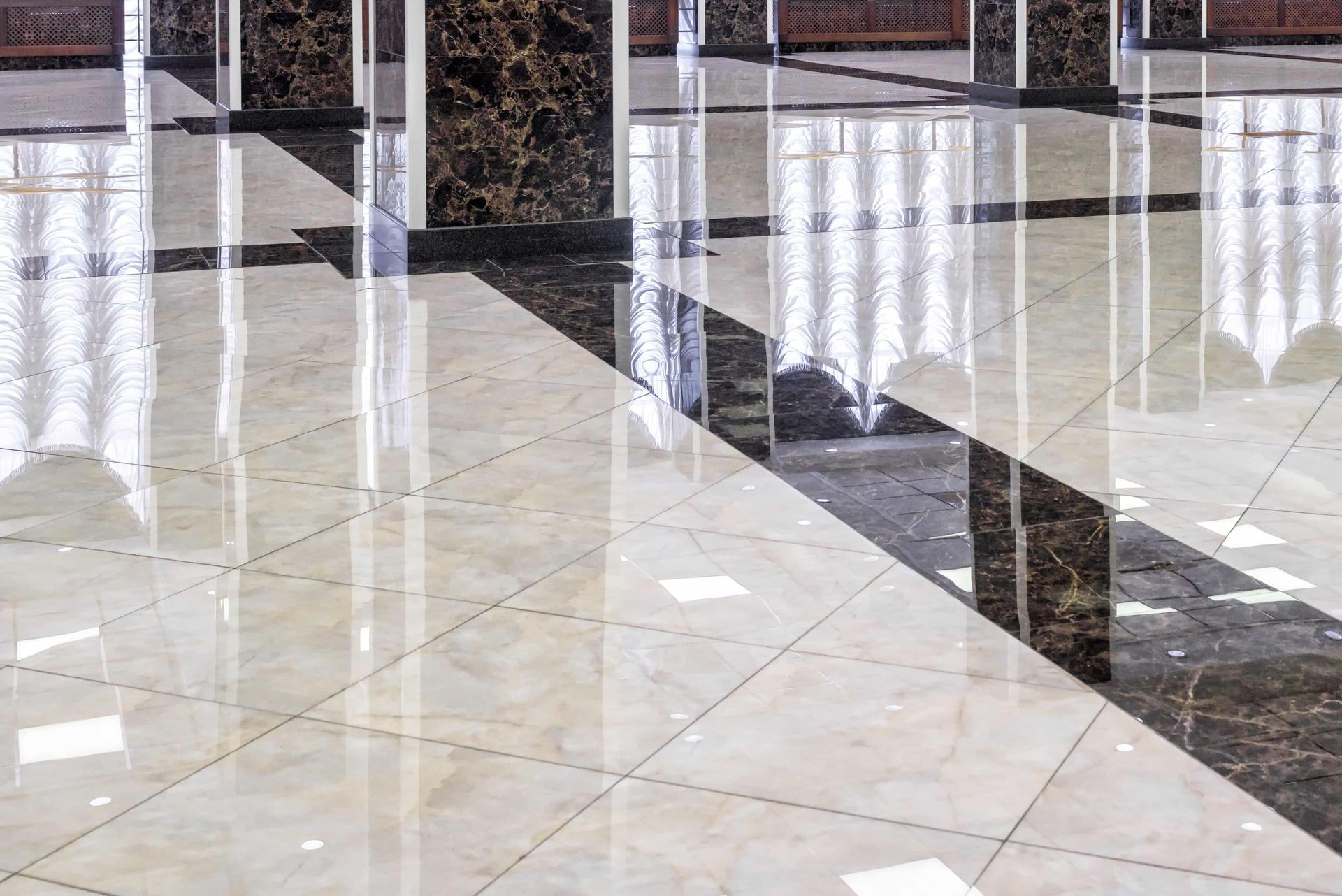 A shiny marble floor with columns in a hallway.