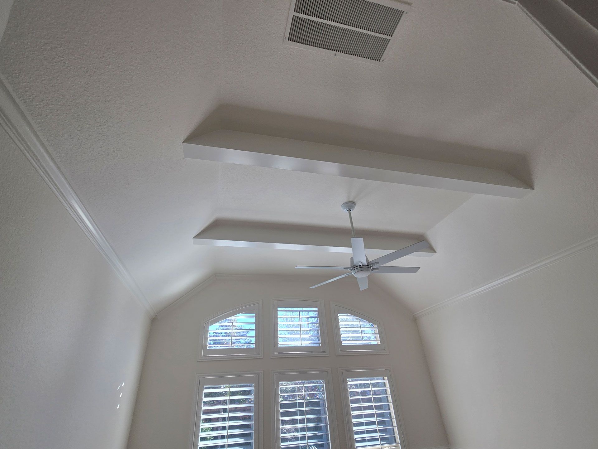 Ceiling with a fan and a window with blinds.