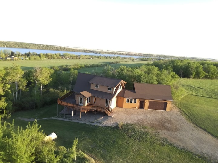 An aerial view of a house with a lake in the background