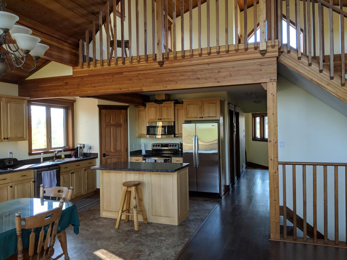 A kitchen with a staircase leading up to the second floor