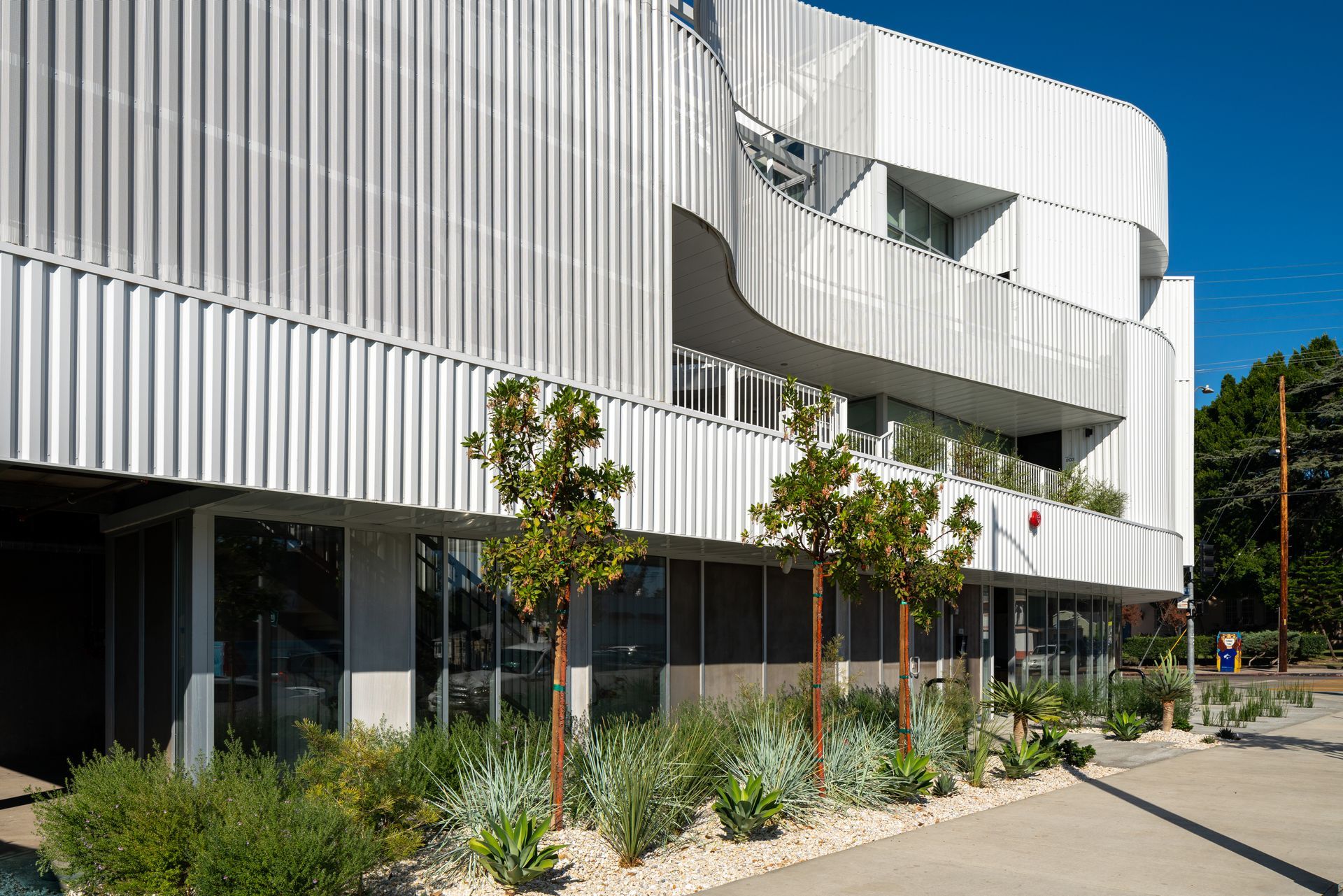 A large white building with a lot of windows and trees in front of it.