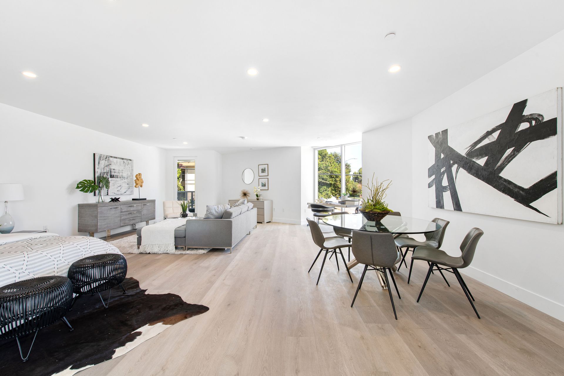 A living room and dining room in a house with a cowhide rug on the floor.