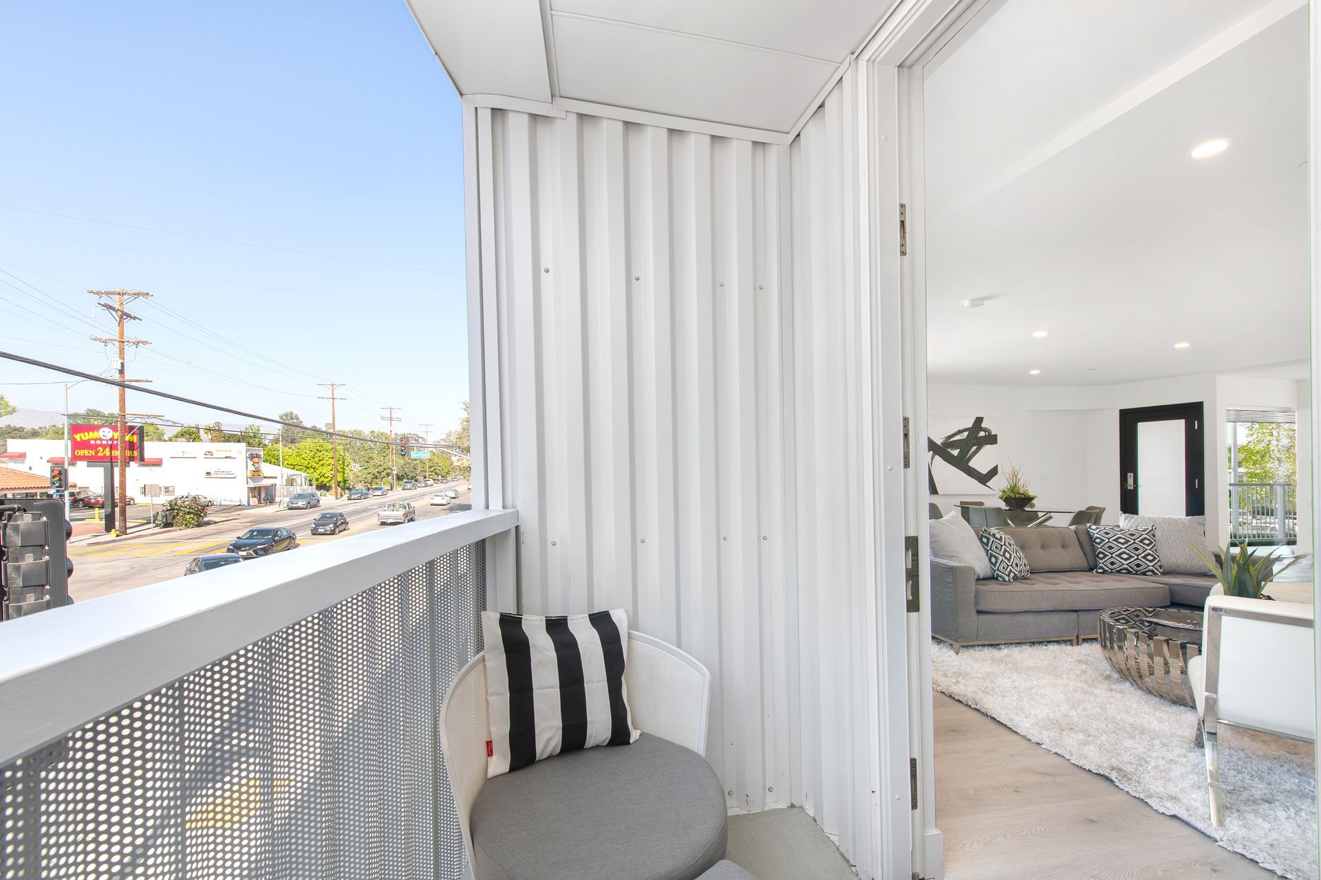 A balcony with a chair and a couch in a living room.