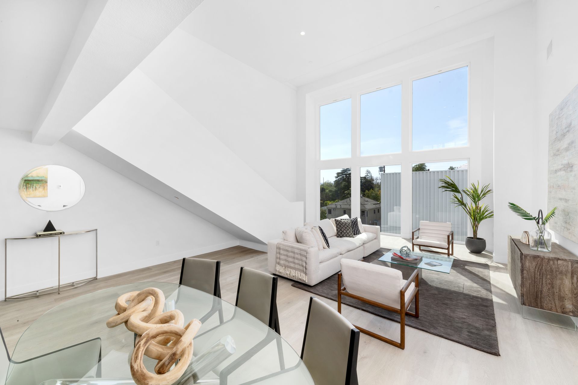 A living room with a dining table and chairs and a staircase.