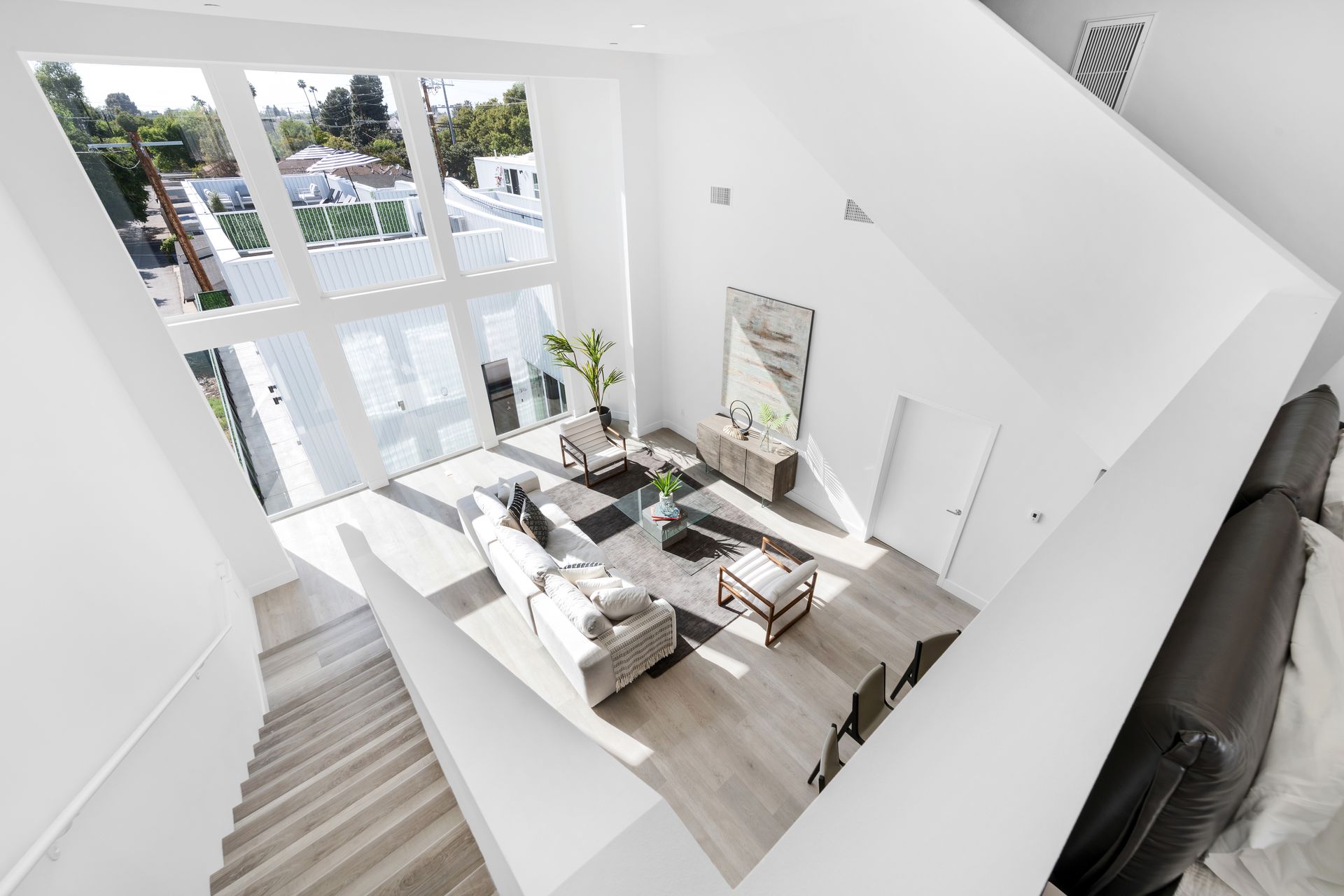 An aerial view of a living room and stairs from the second floor.