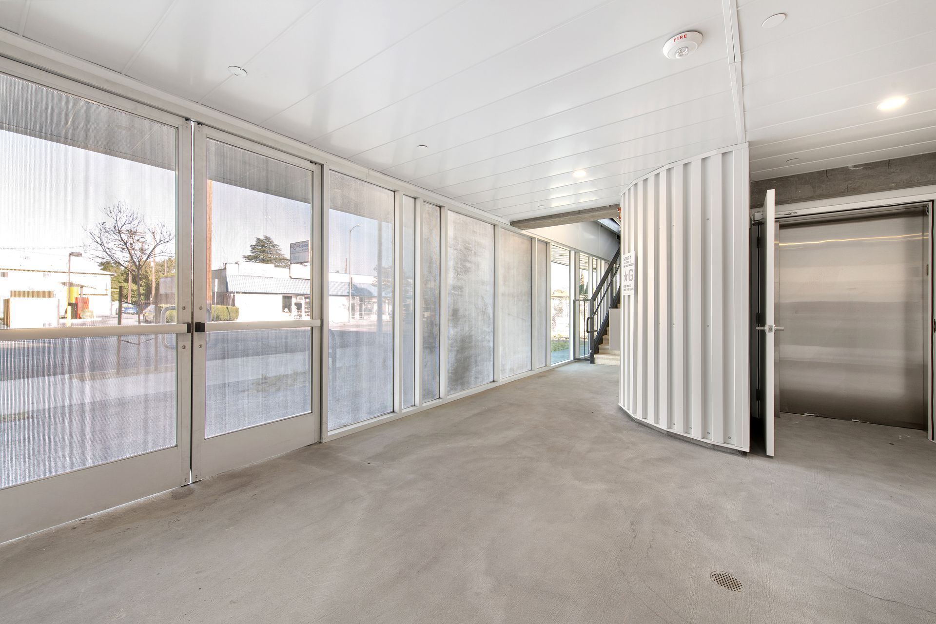 A large empty room with a lot of windows and doors.