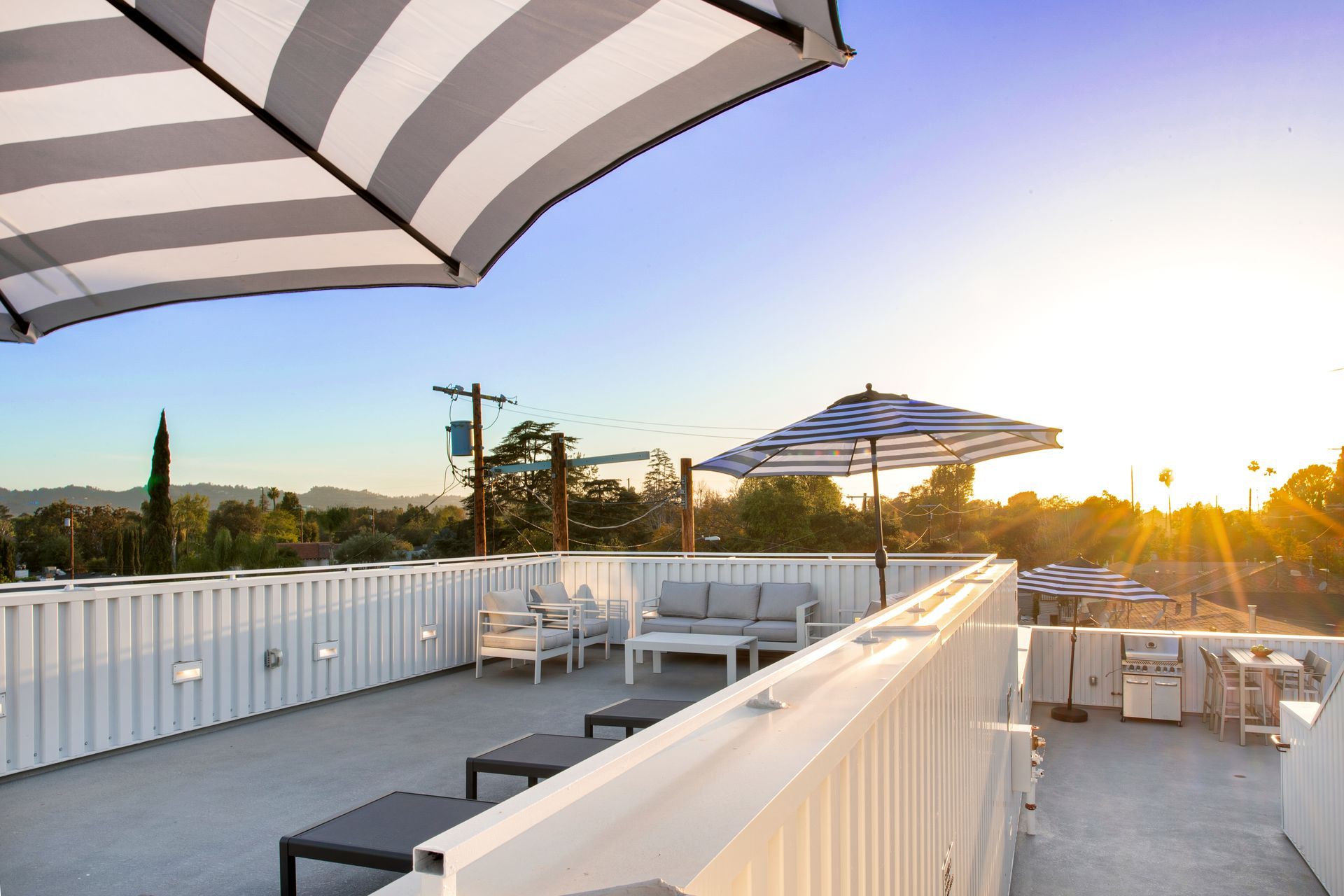 A patio with a striped umbrella and a couch