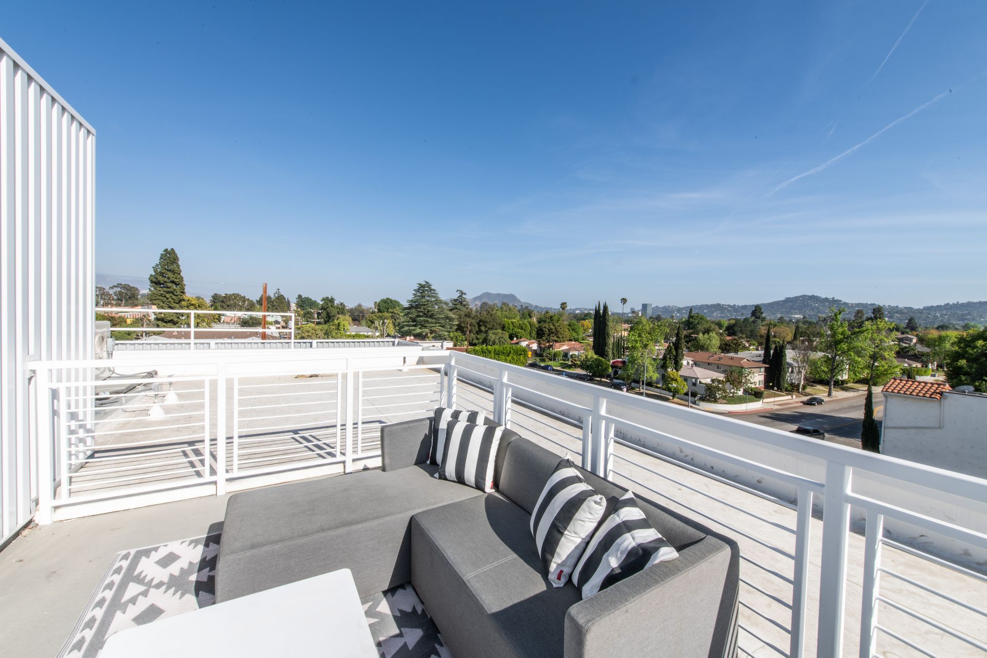 There is a balcony with a couch and a table on it.