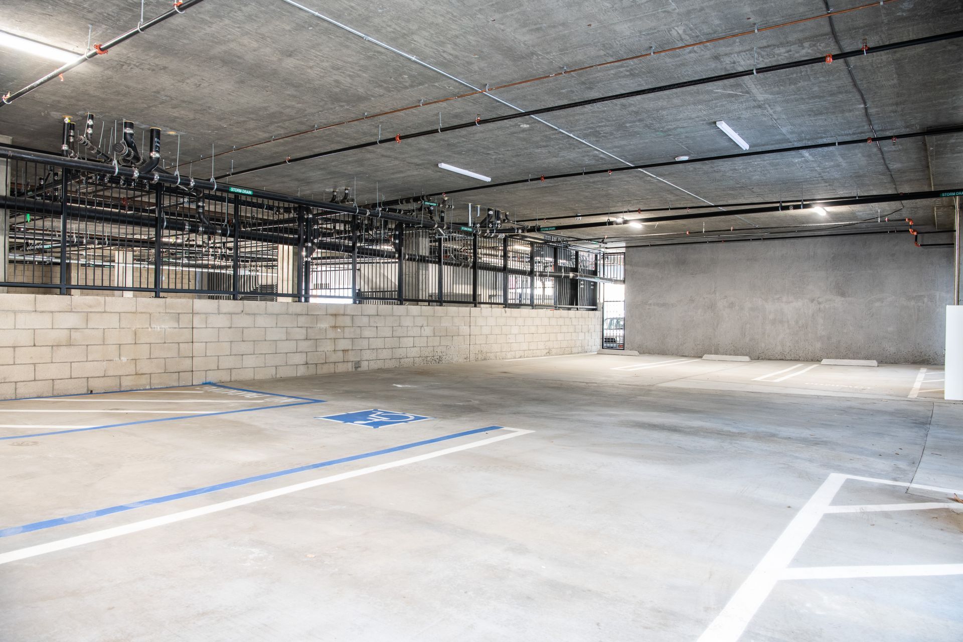An empty parking garage with a handicapped parking spot in the middle.