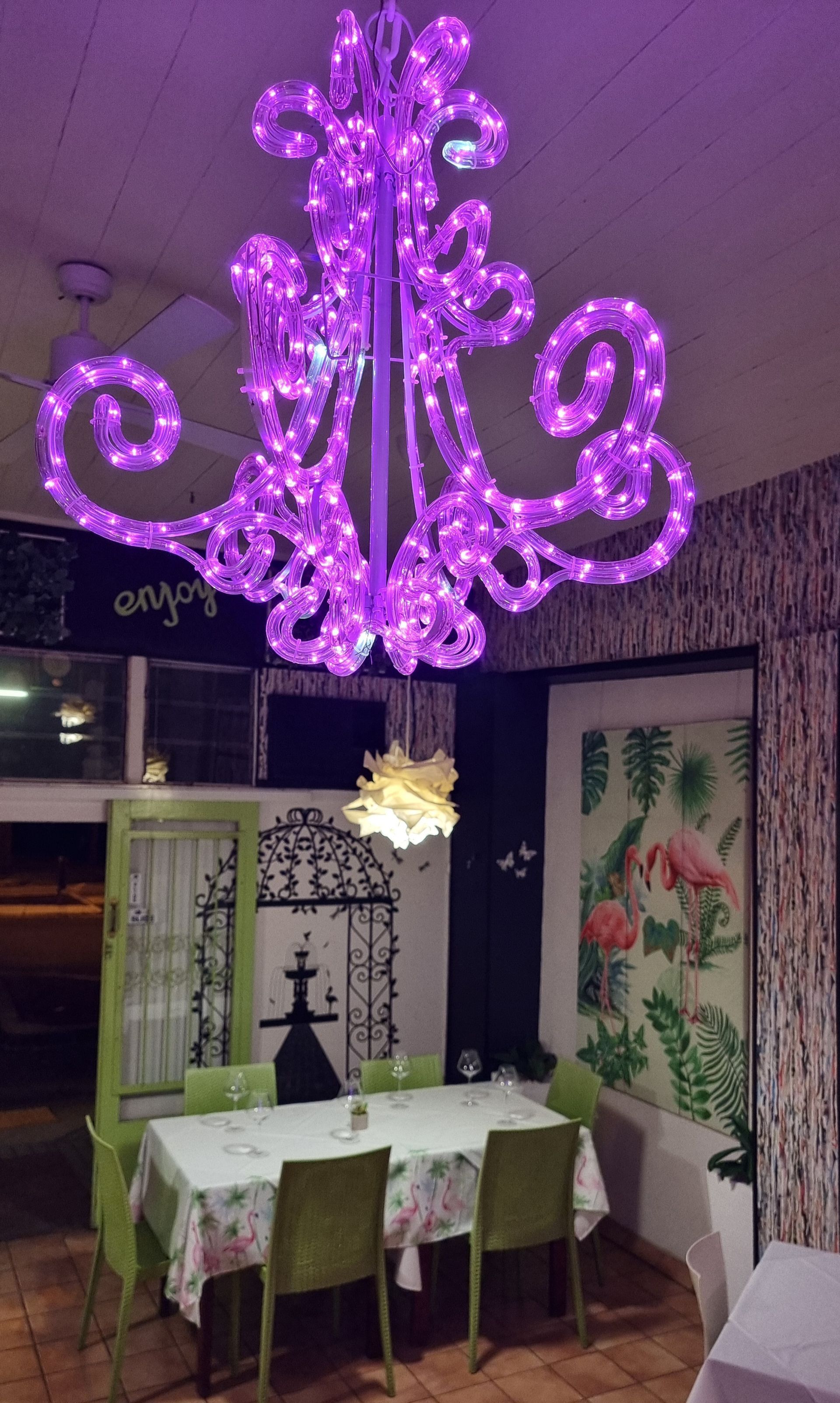 A purple chandelier hangs over a dining room table and chairs  — Wayne & Adele's Garden of Eating BYO Restaurant In South Townsville, QLD