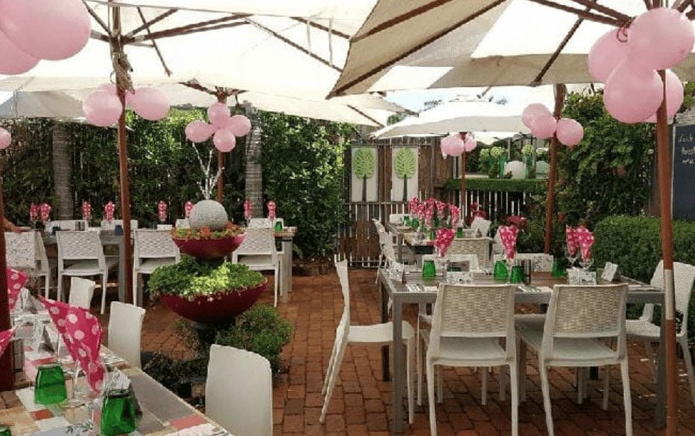 A Restaurant Is Decorated With Pink Balloons And Umbrellas — Wayne & Adele's Garden of Eating BYO Restaurant In South Townsville, QLD