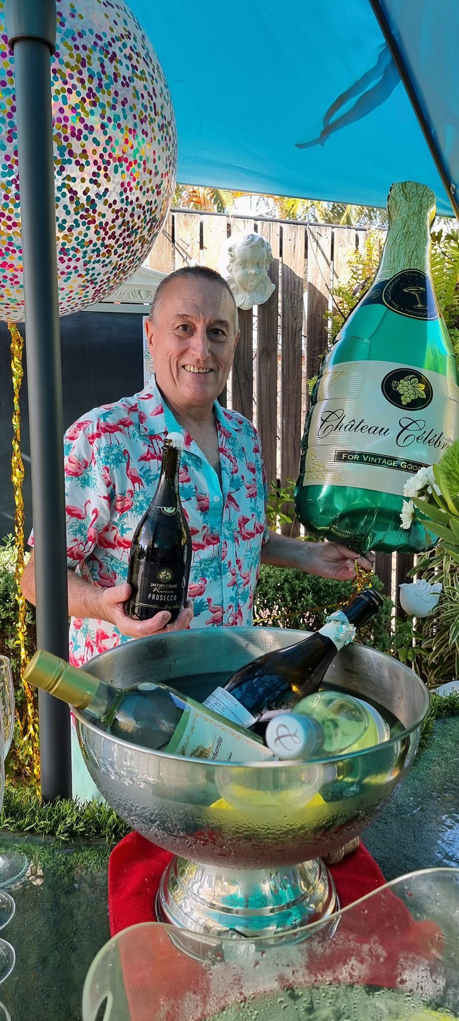 A man is holding two bottles of champagne in front of a bowl of champagne  — Wayne & Adele's Garden of Eating BYO Restaurant In South Townsville, QLD