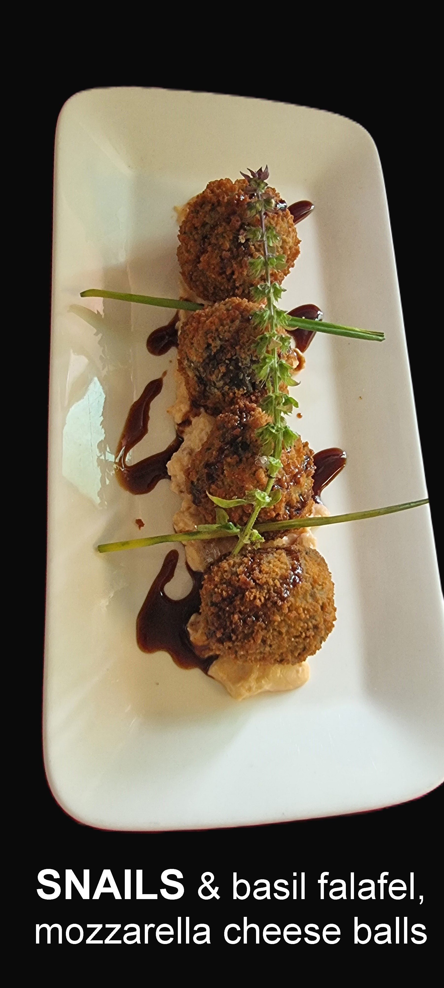 A white plate Topped with Snails and basil falafel  — Wayne & Adele's Garden of Eating BYO Restaurant In South Townsville, QLD