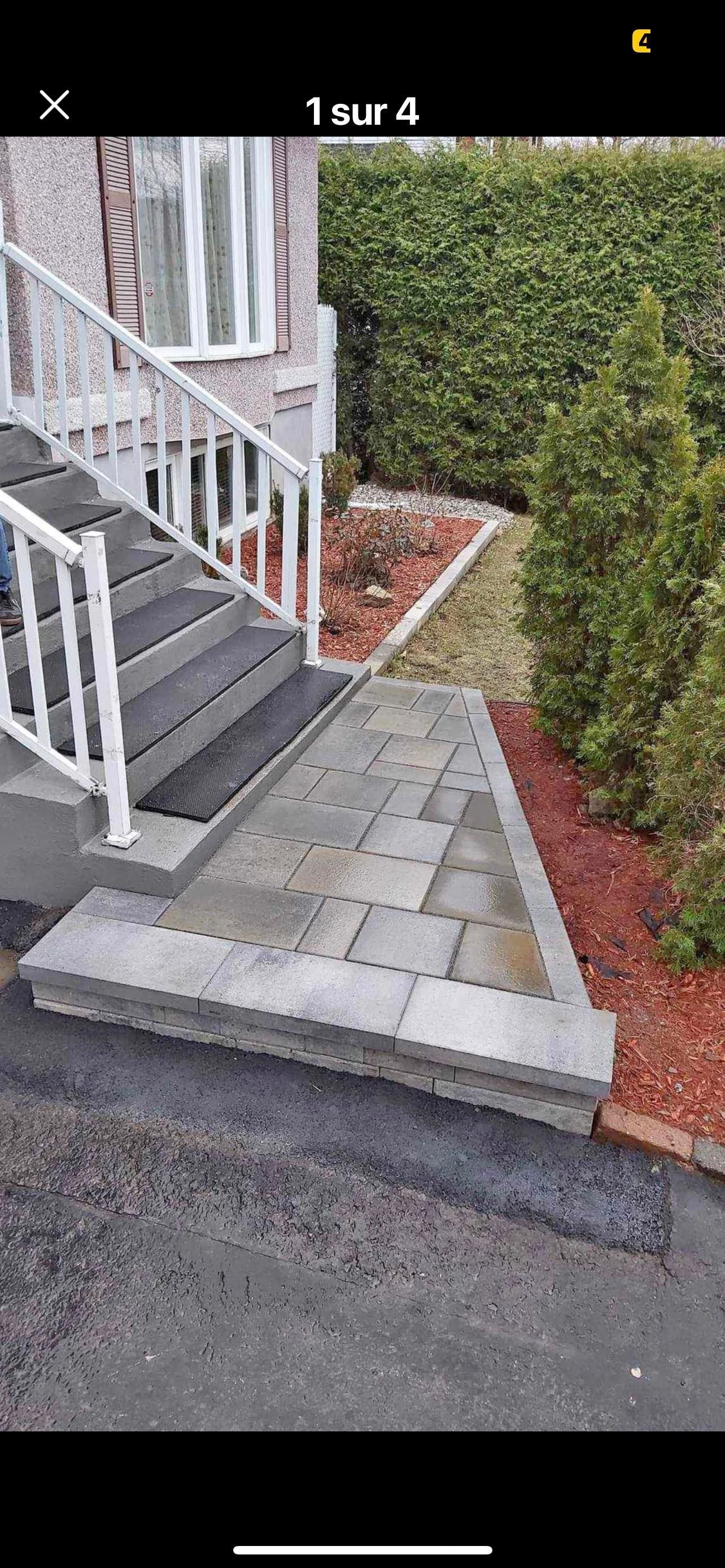 Un escalier menant à une maison avec une rampe blanche.