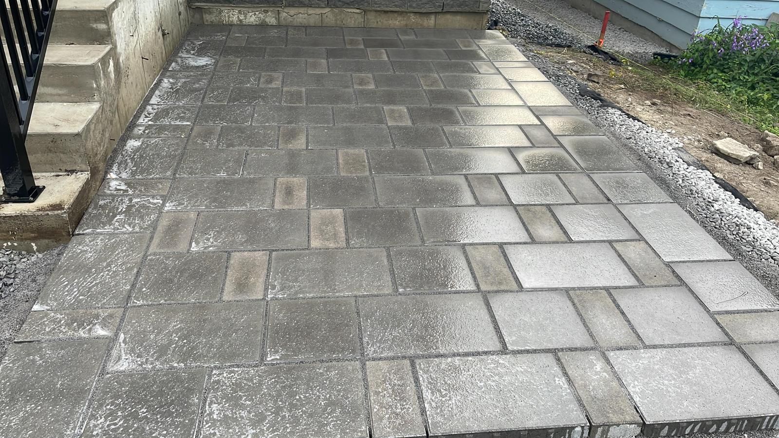 Une passerelle en briques est en cours de construction devant une maison.