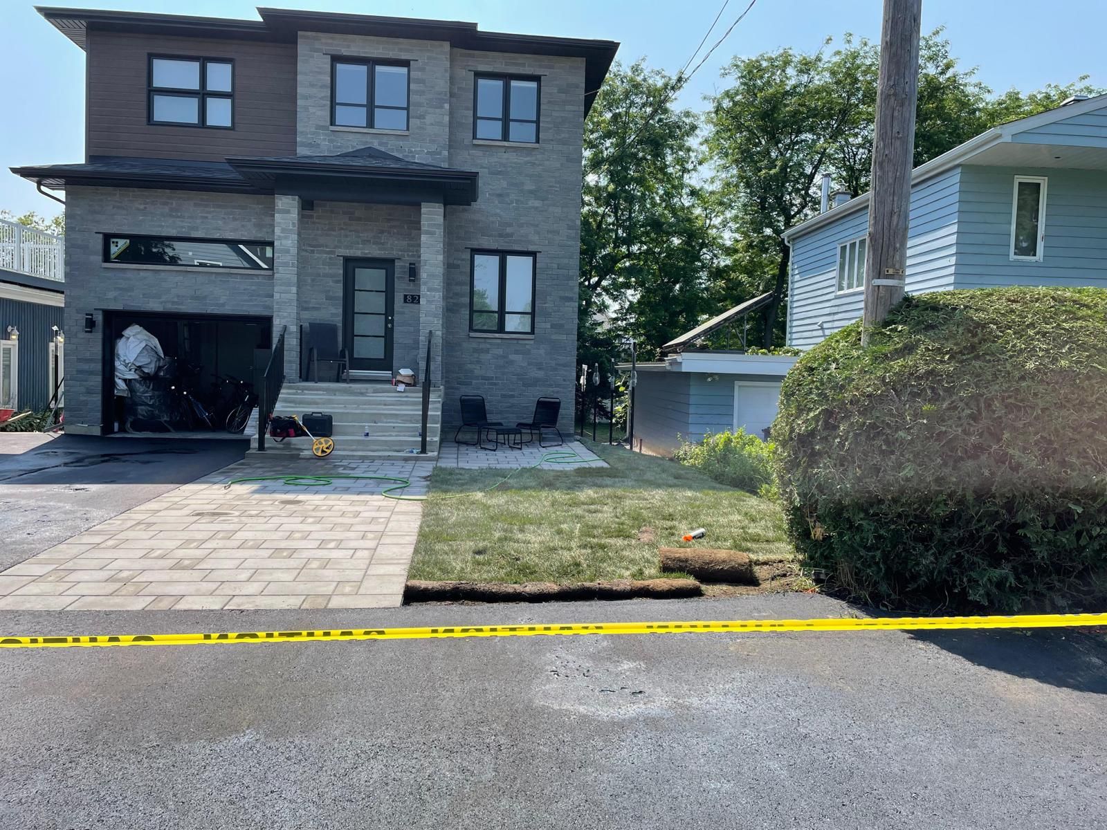 Une grande maison est située sur le bord de la route à côté d'un ruban jaune.