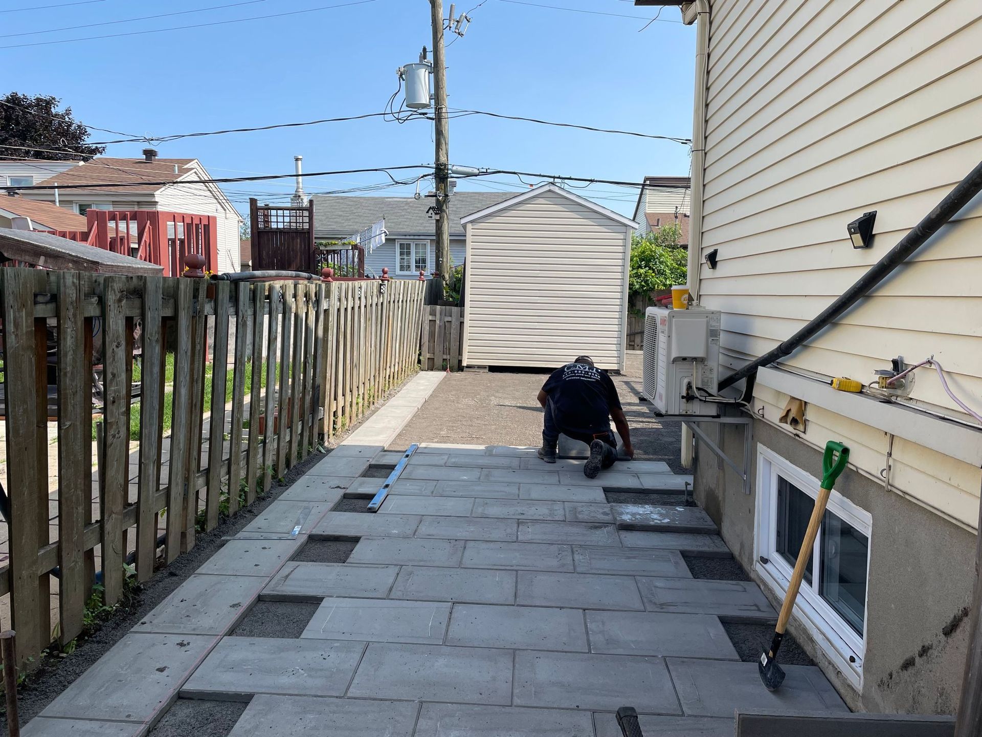 Un homme travaille sur une terrasse devant une maison