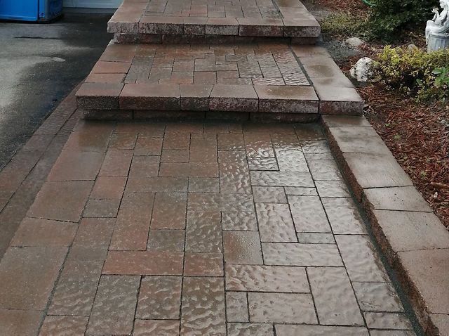 Une allée en briques avec des marches menant à un garage