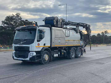 A vacuum truck is parked on the side of the road.