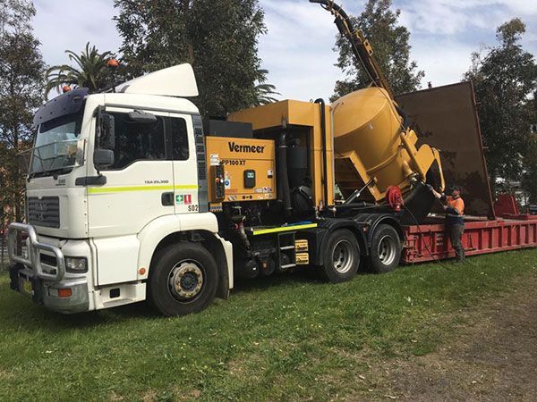 A vacuum truck is parked on the side of the road.