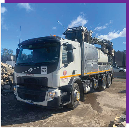 A white volvo truck is parked in a parking lot.