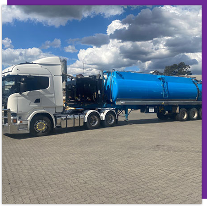 A white truck with a blue tank on the back is parked in a parking lot.