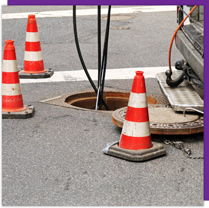 A manhole cover with a bunch of traffic cones on it