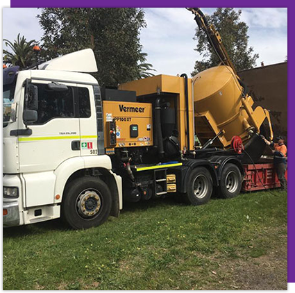 A yellow vermeer truck is parked in the grass