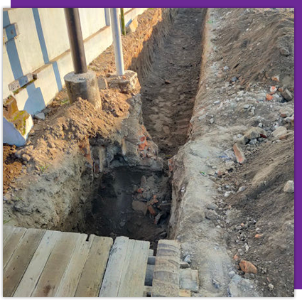 A hole in the ground with a wooden platform in the middle of it.