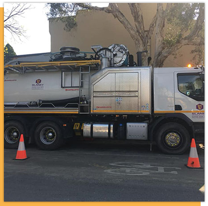 A large tanker truck is parked on the side of the road