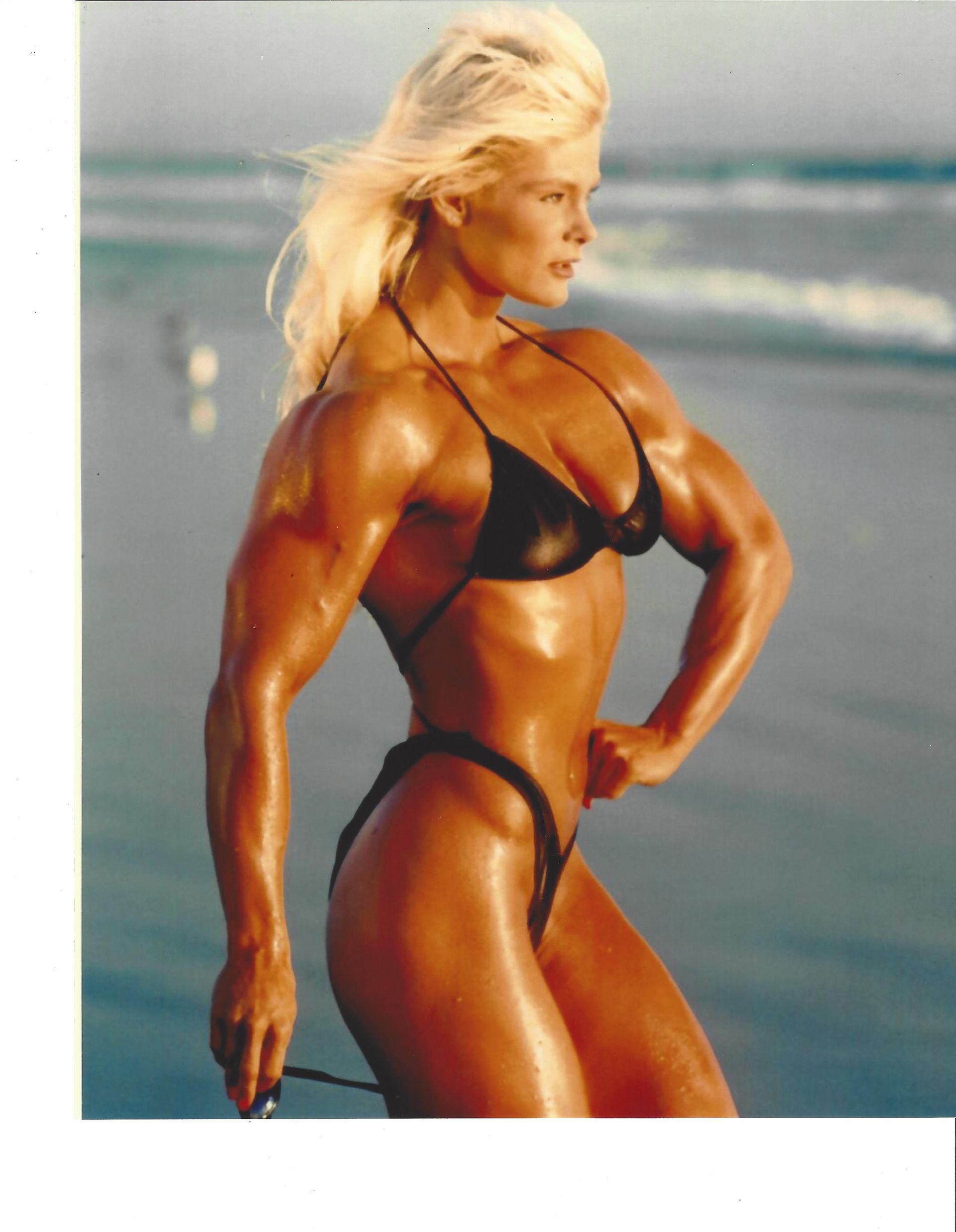 A woman in a bikini is standing on the beach