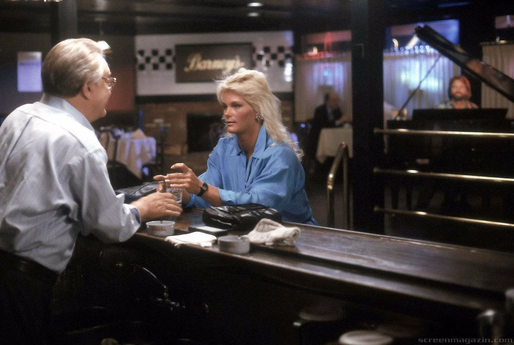 A man and a woman are sitting at a bar talking