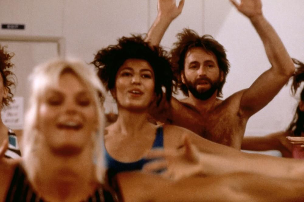 A group of people are dancing with their arms in the air