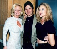 A man and two women are posing for a picture together.