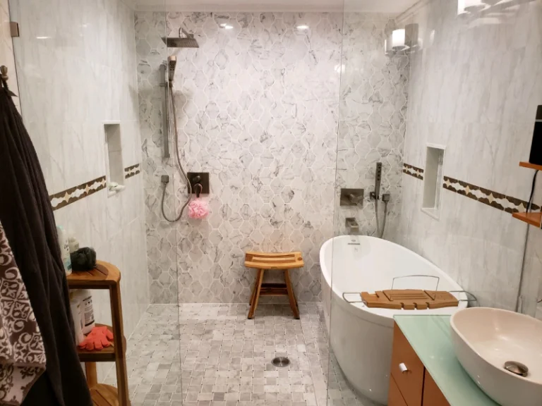 A luxurious white marble bathroom with a shower, freestanding tub, and wooden accents.