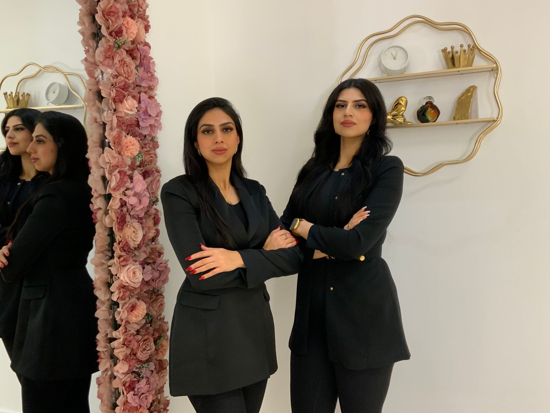 Woman with radiant skin smiles, touches cheek. Beige background.