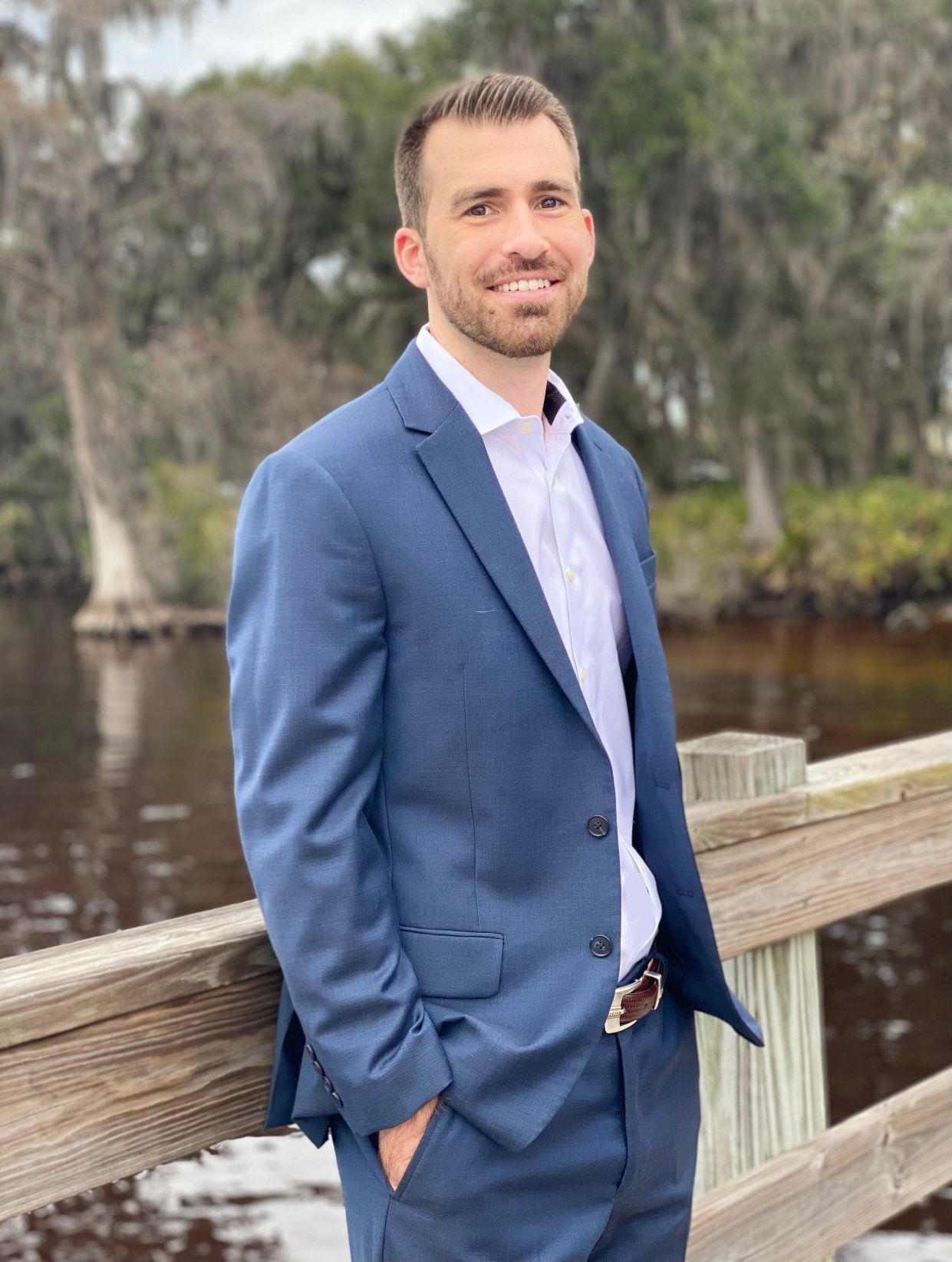 A young girl is sitting at a table with an older woman standing behind her.
