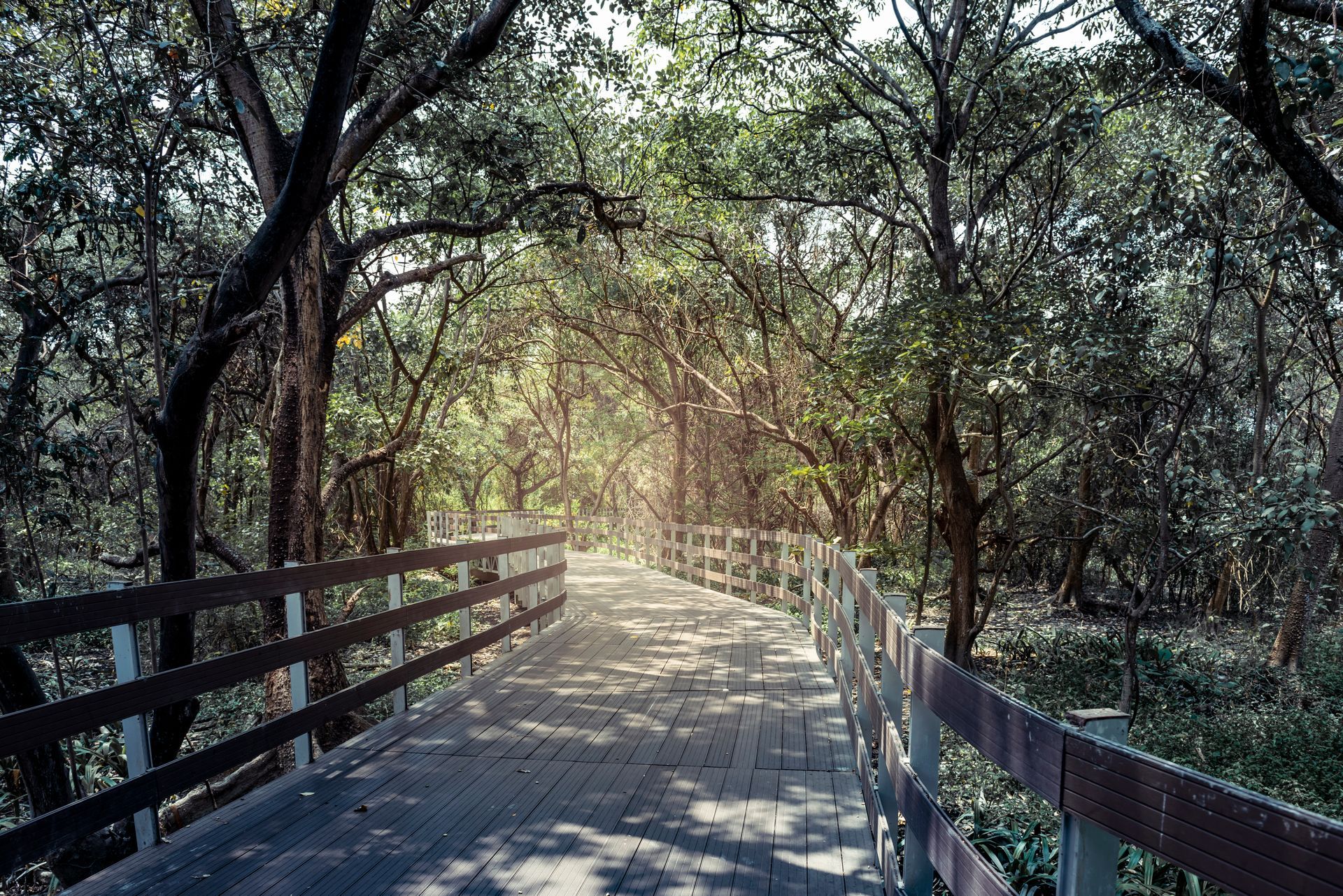 A young girl is sitting at a table with an older woman standing behind her.