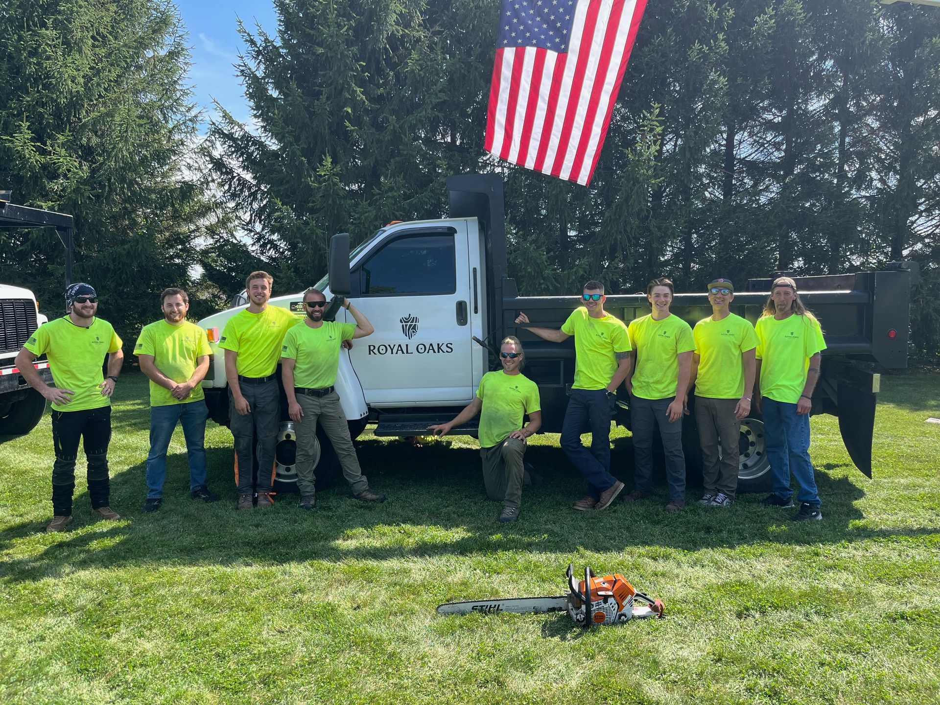 A group of men are posing for a picture in front of a truck.