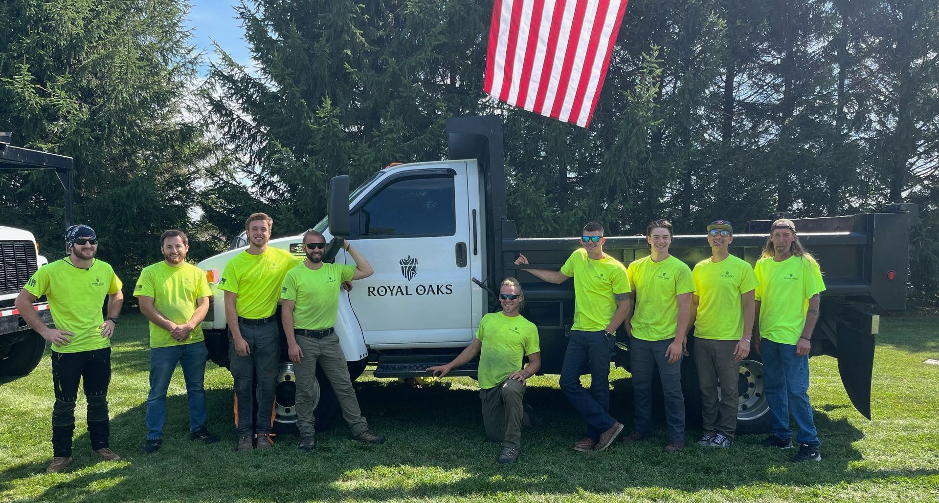 A group of men are posing for a picture in front of a truck.