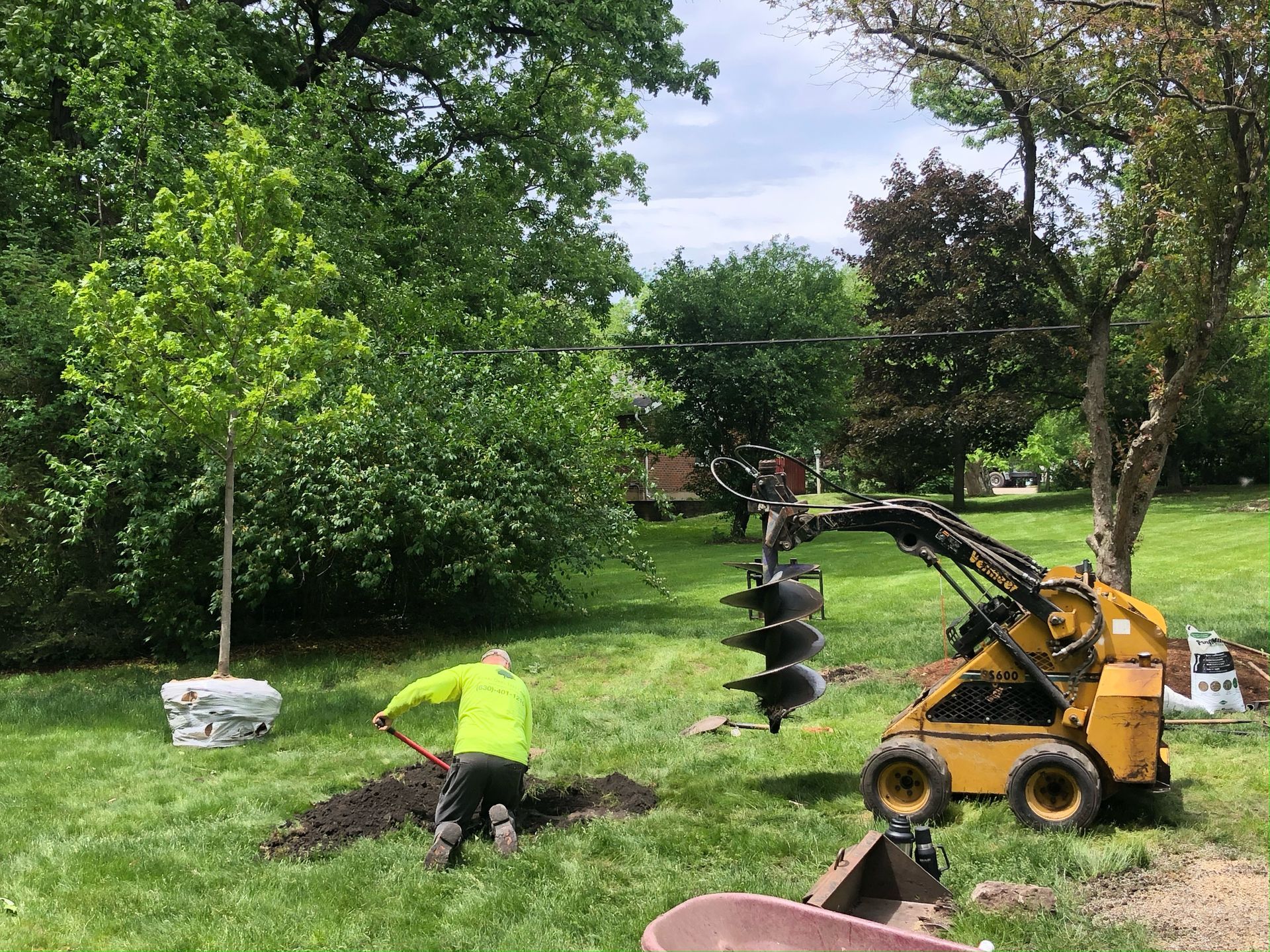 A man is digging a hole in the ground to plant a tree.