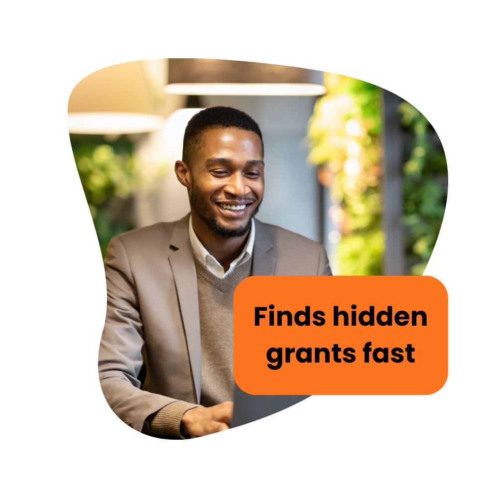 Smiling man in a blazer looking at laptop, with text