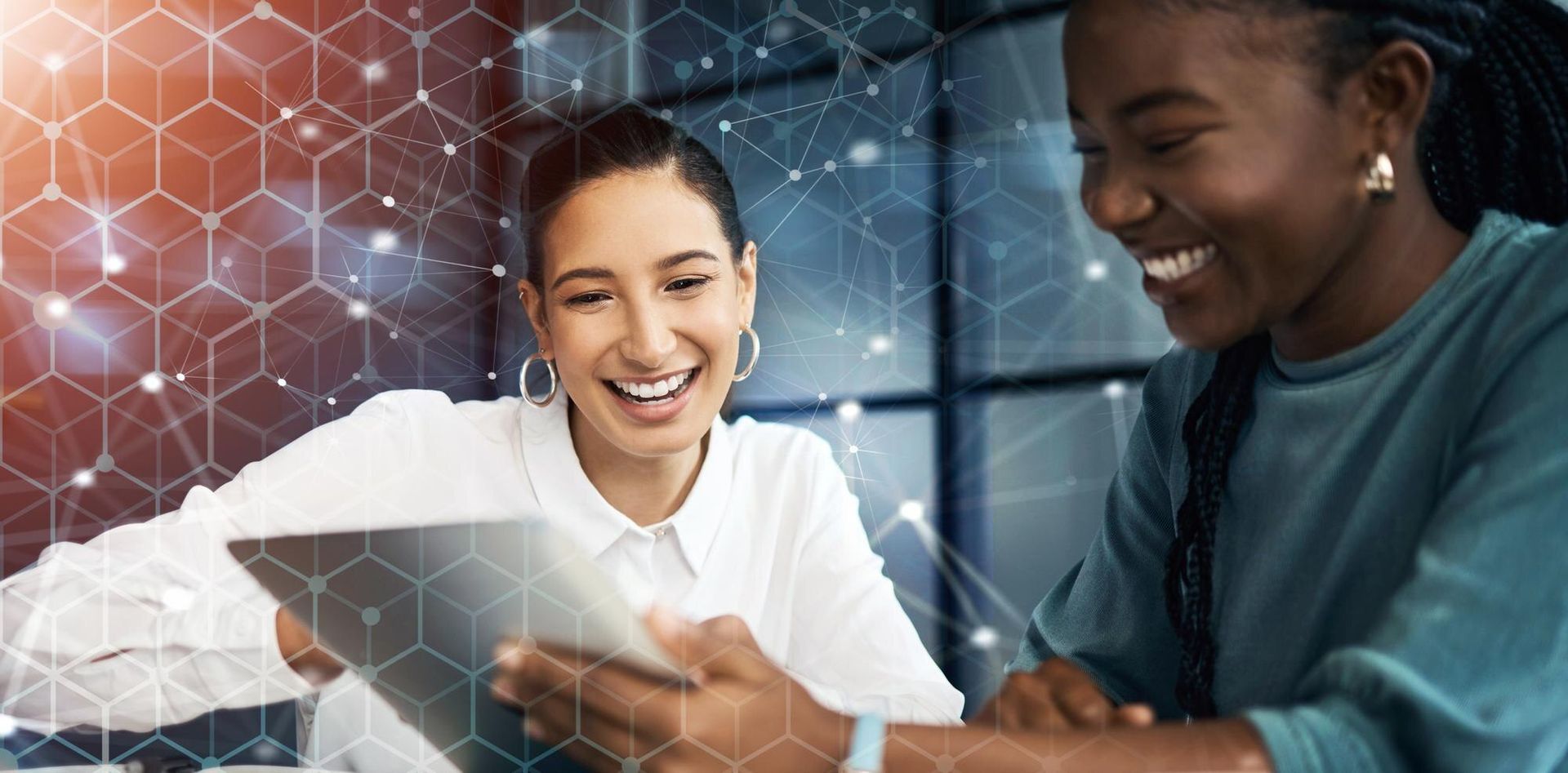 Two people looking at a tablet, smiling. Background features geometric shapes and lights.