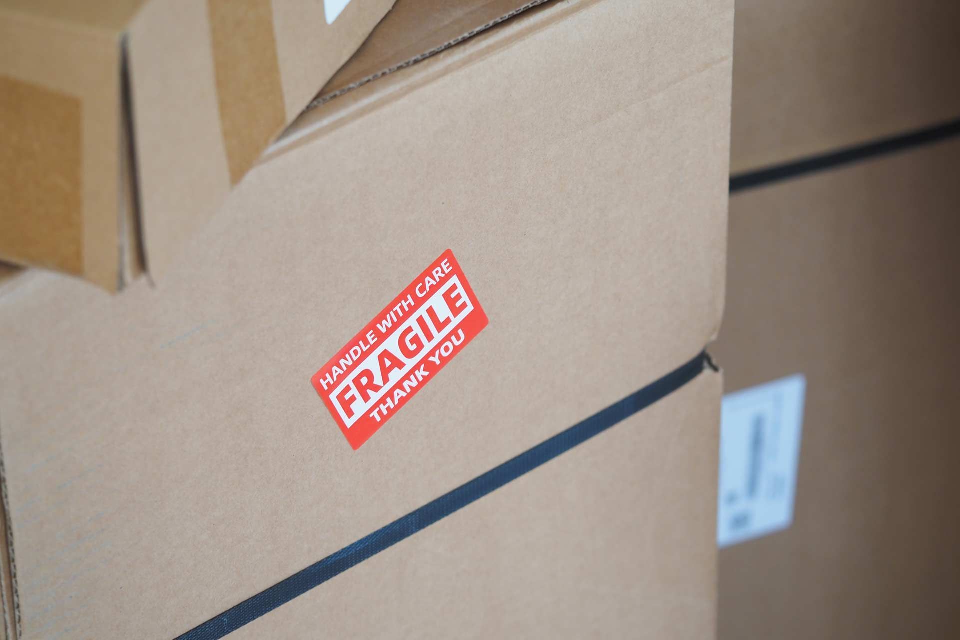 Cardboard boxes stacked, one with a red 