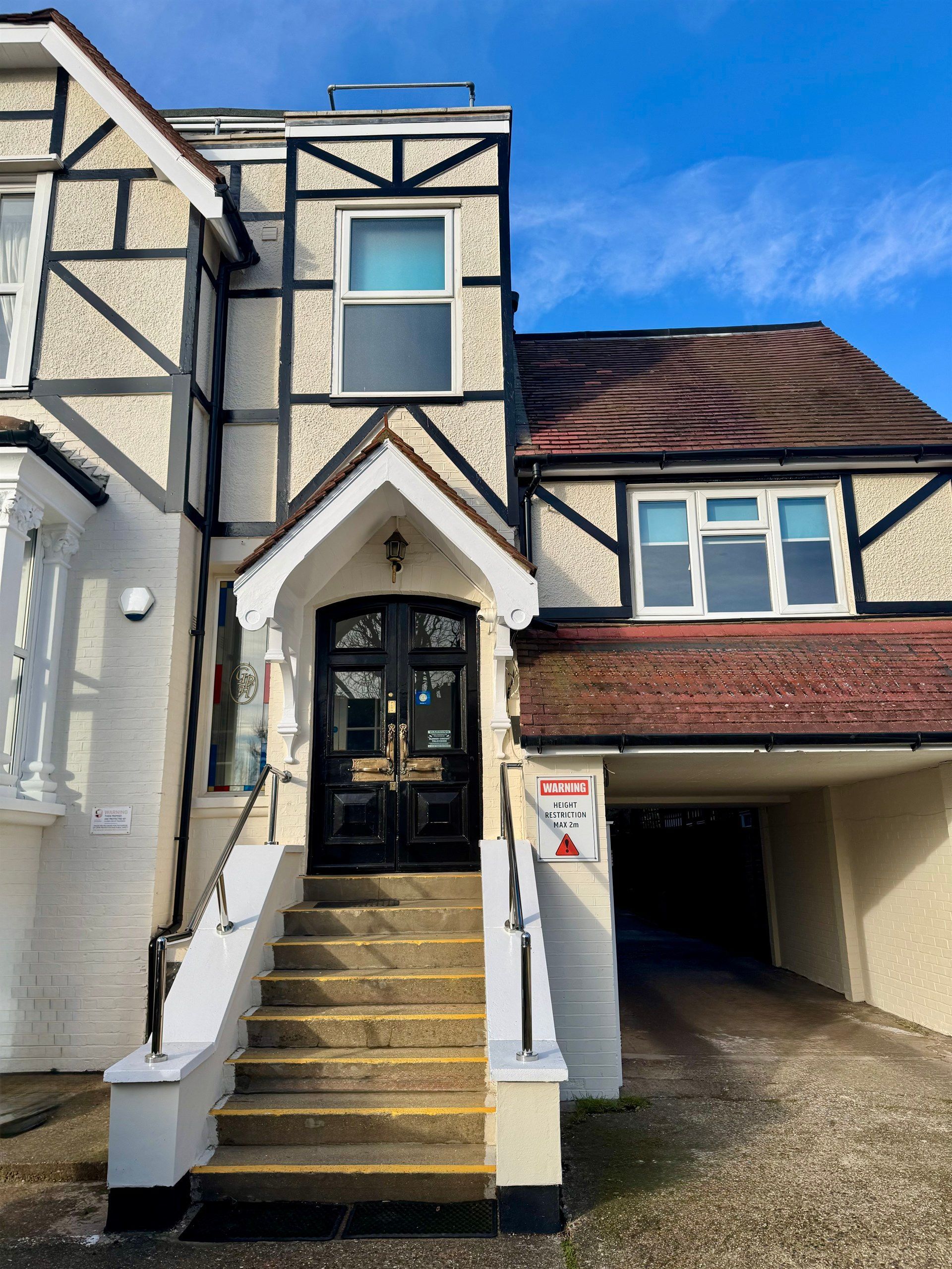 A large house with stairs leading up to the front door