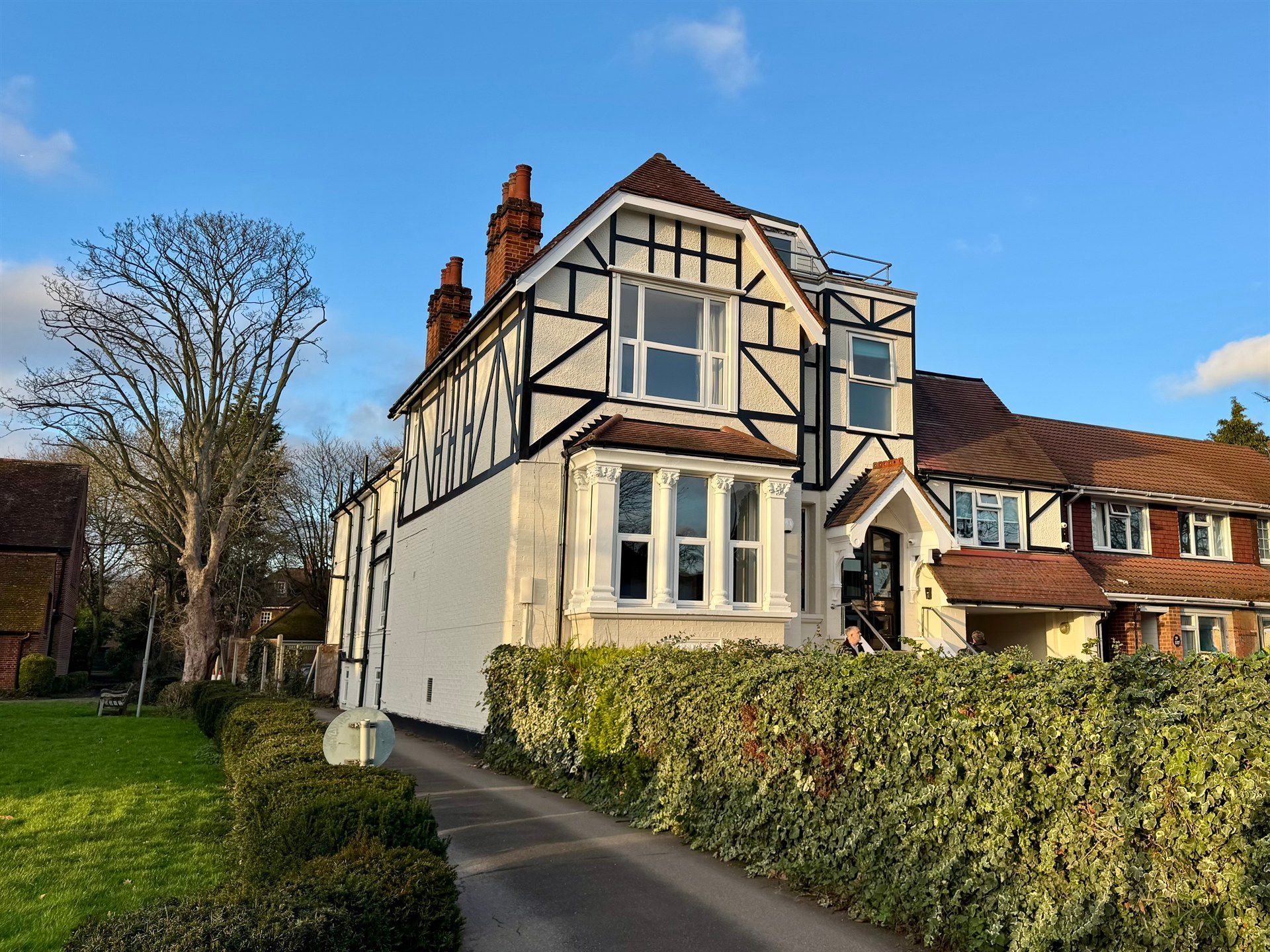 A large white and brown house with a driveway leading to it.